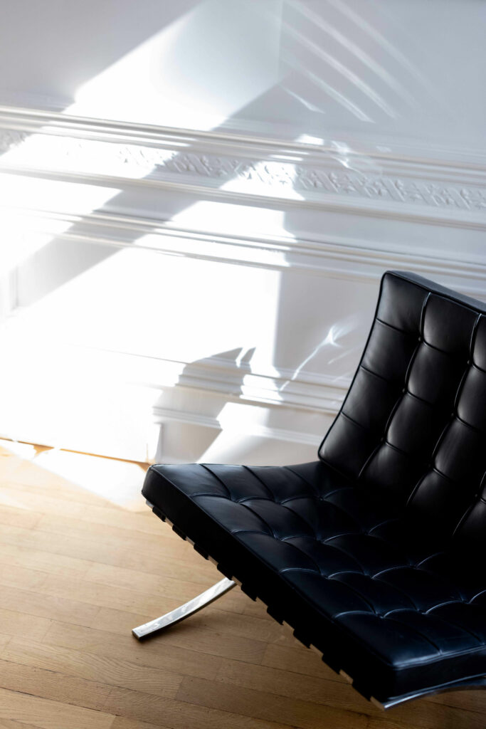 Fauteuil en cuir noir dans un intérieur lumineux, univers de direction artistique MNDS